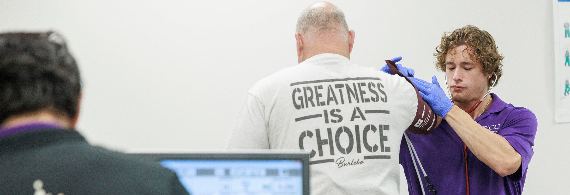 Student registering blood pressure of firefighter during an exercise stress test at the Human Performance Lab.