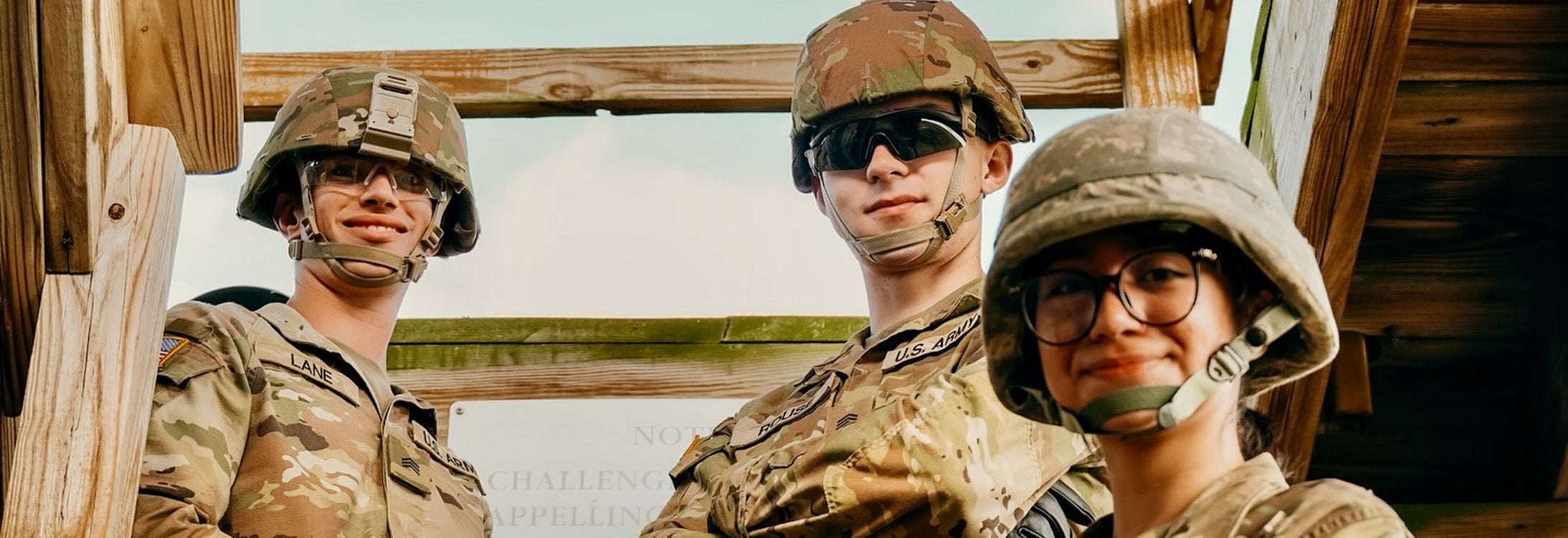 Three ROTC cadets stand on wood steps to tower.