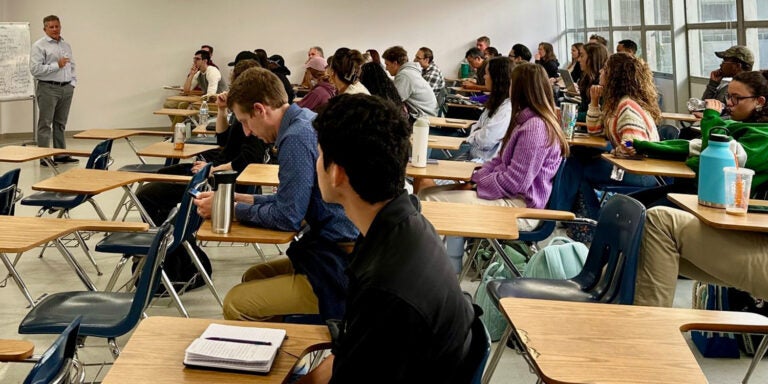 Students sitting in a classroom listen to a lecture.