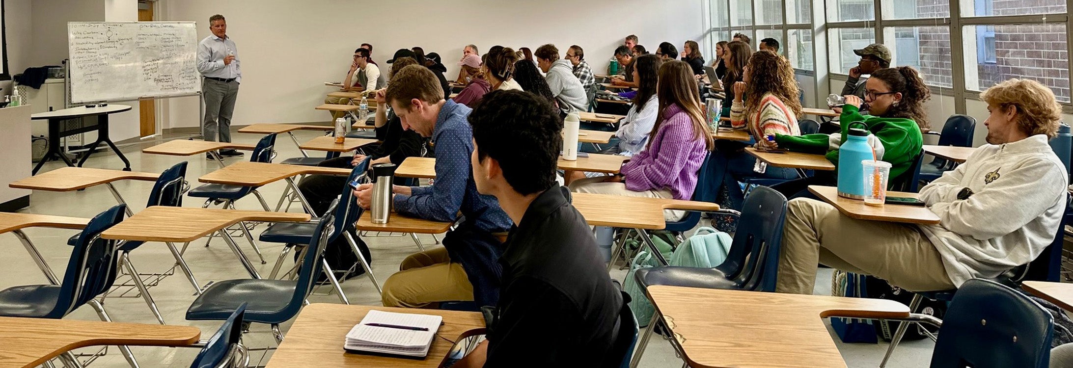 Students sitting in a classroom listen to a lecture.