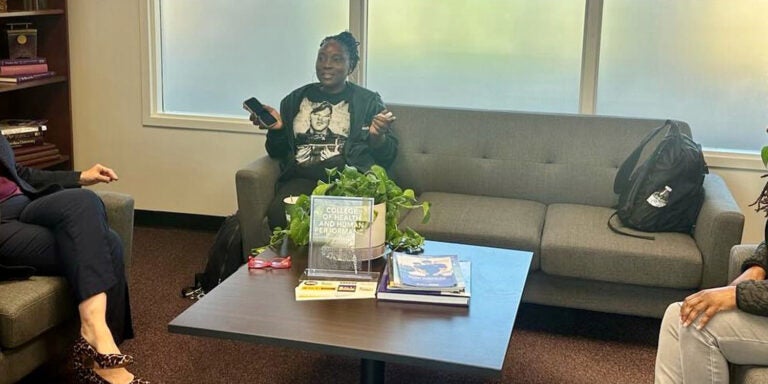 Three women talking and lounging in office setting.