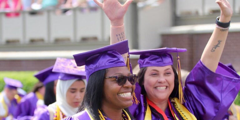 Juliann Mullen raises her hands among happy East Carolina University graduates at Dowdy-Ficklen Stadium on May 3. (contributed photo)