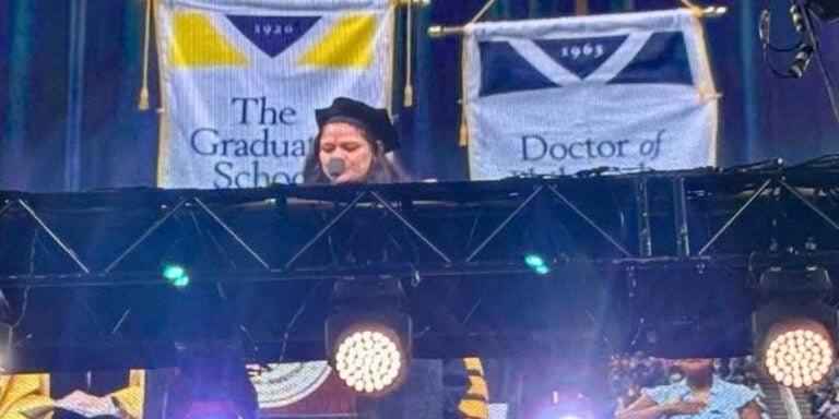 Faculty member Anu Hegde speaks at a podium during graduation event.