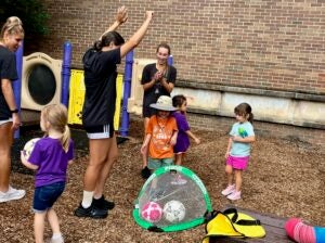 ECU soccer players clap for children playing at the Nancy W. Darden Child Development Center. 