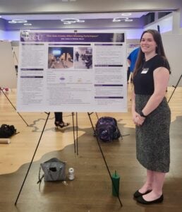 Student Ellie Cleary stands with her poster during ECU Research and Creative Activity Week.