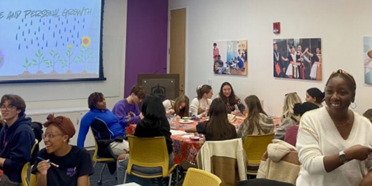 Students sitting at tables doing artwork.