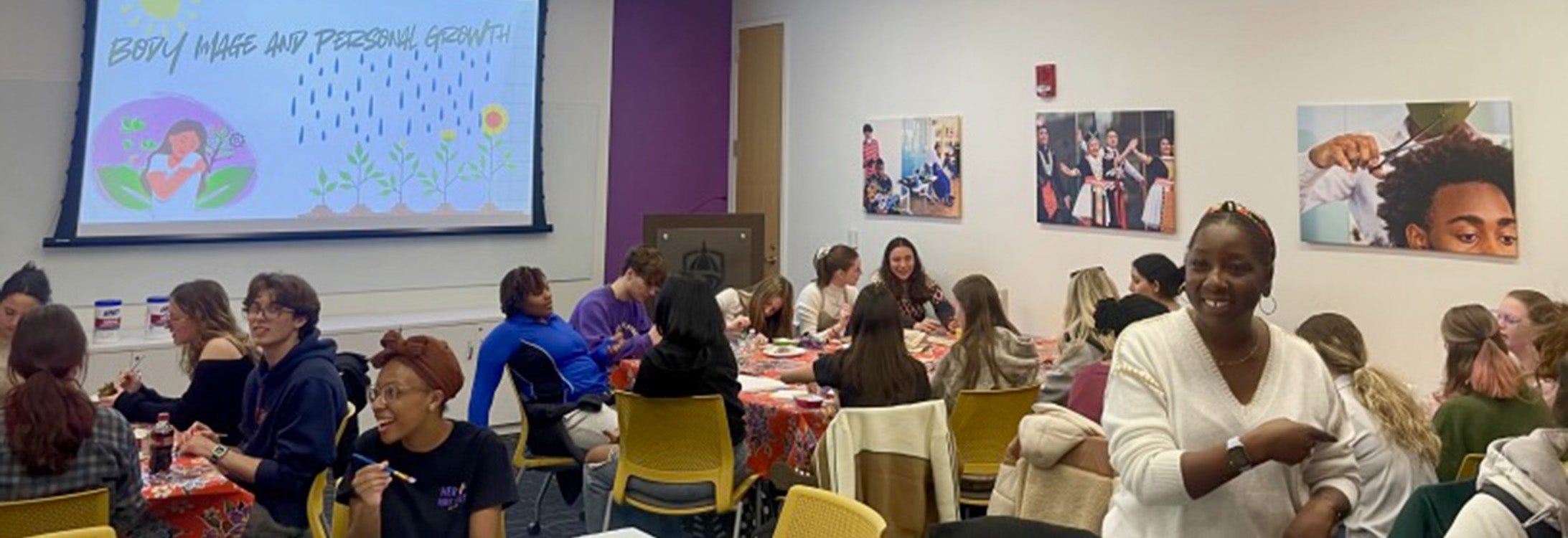 Students sitting at tables doing artwork.