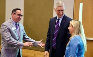 Jennifer Hodgson, right, is greeted by senior associate vice chancellor Greg Abeyounis and Chancellor Philip Rogers at a faculty and staff appreciation breakfast. (George Crocker photo) 